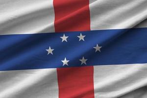 Netherlands Antilles flag with big folds waving close up under the studio light indoors. The official symbols and colors in banner photo