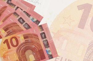 Los billetes de 10 euros se encuentran apilados sobre el fondo de un gran billete semitransparente. fondo de negocios abstracto foto