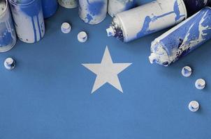 Somalia flag and few used aerosol spray cans for graffiti painting. Street art culture concept photo