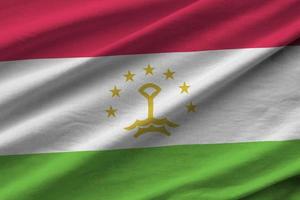 bandera de tayikistán con grandes pliegues ondeando de cerca bajo la luz del estudio en el interior. los símbolos y colores oficiales en banner foto