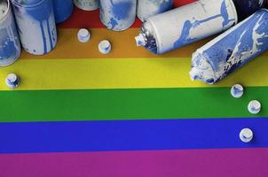 LGBT community flag and few used aerosol spray cans for graffiti painting. Street art culture concept