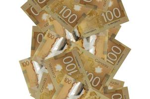 100 Canadian dollars bills flying down isolated on white. Many banknotes falling with white copyspace on left and right side photo