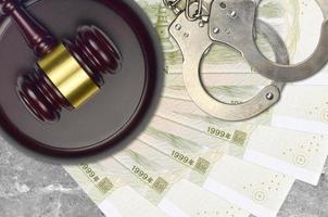 1 Chinese yuan bills and judge hammer with police handcuffs on court desk. Concept of judicial trial or bribery. Tax avoidance photo