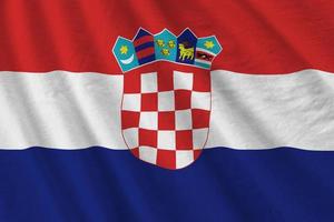 Croatia flag with big folds waving close up under the studio light indoors. The official symbols and colors in banner photo