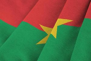 bandera de burkina faso con grandes pliegues ondeando de cerca bajo la luz del estudio en el interior. los símbolos y colores oficiales en banner foto