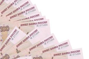 100 russian rubles bills lies isolated on white background with copy space stacked in fan close up photo