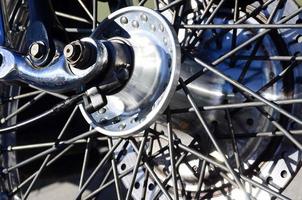 Fragment of chromed shiny wheel of old classic motorbike photo