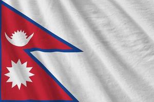 Nepal flag with big folds waving close up under the studio light indoors. The official symbols and colors in banner photo