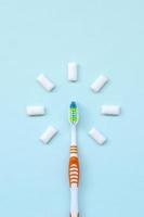 Toothbrush and chewing gums lie on a pastel blue background. Top view, flat lay. Minimal concept photo
