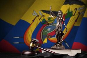 bandera de ecuador con estatua de la dama de la justicia, constitución y martillo de juez sobre cortinas negras. concepto de juicio y culpa foto