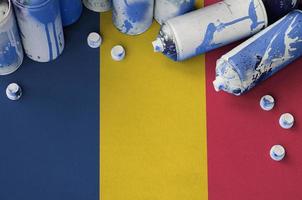 Chad flag and few used aerosol spray cans for graffiti painting. Street art culture concept