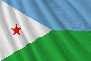 Djibouti flag with big folds waving close up under the studio light indoors. The official symbols and colors in banner photo