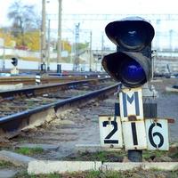 semáforo con luz azul ardiente. la intersección de las vías del tren foto