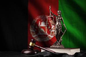 Afghanistan flag with statue of lady justice, constitution and judge hammer on black drapery. Concept of judgement and guilt photo