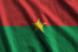 Burkina Faso flag with big folds waving close up under the studio light indoors. The official symbols and colors in banner photo