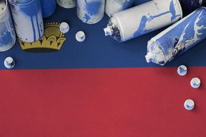 Liechtenstein flag and few used aerosol spray cans for graffiti painting. Street art culture concept photo