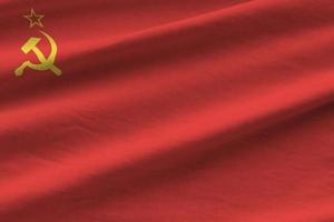 Soviet Union flag with big folds waving close up under the studio light indoors. The official symbols and colors in banner photo