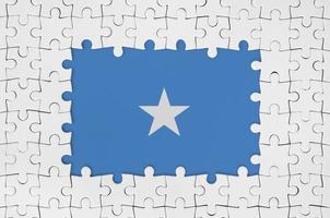 Somalia flag in frame of white puzzle pieces with missing central part photo