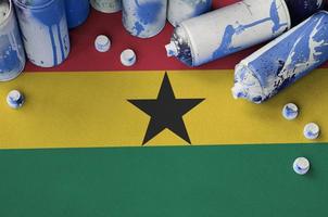 Ghana flag and few used aerosol spray cans for graffiti painting. Street art culture concept photo