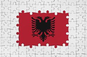 Albania flag in frame of white puzzle pieces with missing central part photo