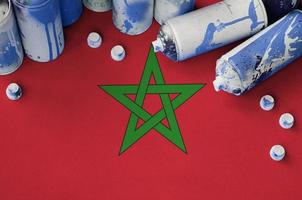 Morocco flag and few used aerosol spray cans for graffiti painting. Street art culture concept