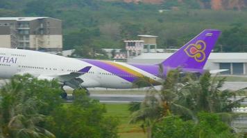 phuket, thaïlande 2 décembre 2016 - thai airways boeing 747 hs tga atterrissant sur l'aéroport de phuket. vue depuis le dernier étage de l'hôtel centara grand west sands resort phuket video