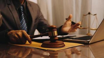 Justice and law concept.Male judge in a courtroom with the gavel, working with, computer and docking keyboard, eyeglasses, on table in morning light video