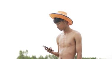 tir en contre-plongée, fermier asiatique sans chemise homme dans un porte-chapeau et parlant au téléphone portable dans les ennuis et sérieusement video