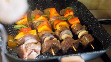 marinated beef kebabs with vegetables prepared on the grill. The cook turns the meat to fry elsewhere video