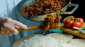 Der Koch gießt Kalbschorizo über den Burrito video