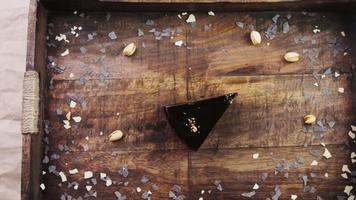 Banana chocolate cake with gold dust on a wooden tray with decorations video