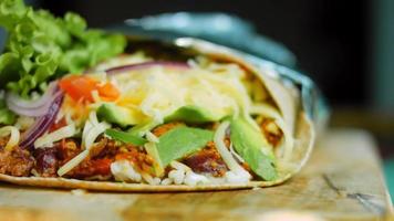 Very large burrito with avocado and chorizo meat. Filming in a romantic setting. Macro shooting video