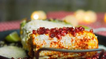 Mexicaans maïs Elote in drie manieren. ingedrukt met kaas, guacamole en granaatappel. maxicaans vlag video