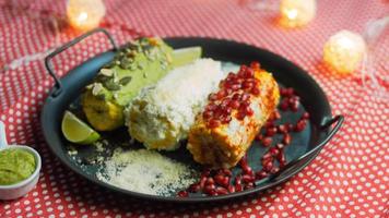 elote de maíz mexicano en tres formas. prensado con queso, guacamole y granada. bandera maxicana video