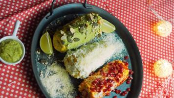 Mexicaans maïs Elote in drie manieren. ingedrukt met kaas, guacamole en granaatappel. maxicaans vlag