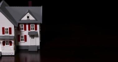 langzaam pannen van miniatuur model- huis Aan donker hout oppervlak. video