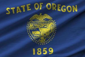 Oregon US state flag with big folds waving close up under the studio light indoors. The official symbols and colors in banner photo