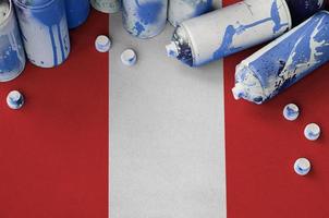 bandera peruana y pocas latas de aerosol usadas para pintar graffiti. concepto de cultura de arte callejero foto