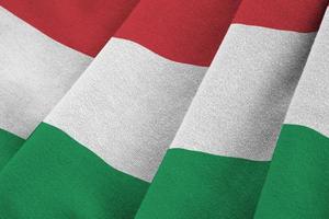 Hungary flag with big folds waving close up under the studio light indoors. The official symbols and colors in banner photo