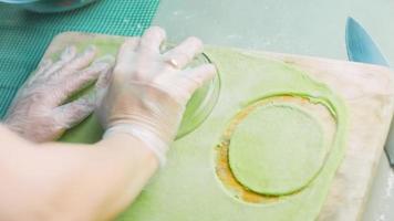 The chef spreads the green dough with a rolling pin. Tortillas prepared and decorated with spinach and beets. Red and green tortillas video