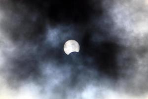 eclipse solar: la luna bloquea parcialmente el sol de un observador en la tierra. foto