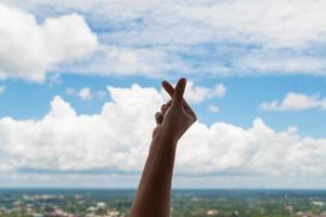 manos rezando en el fondo del cielo azul, joven orado, religión y espiritualidad con creencia foto