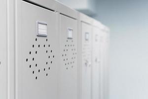 Gray metal lockers in the dressing room for clothes in a row. photo