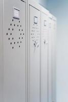 Gray metal lockers in the dressing room for clothes in a row. photo