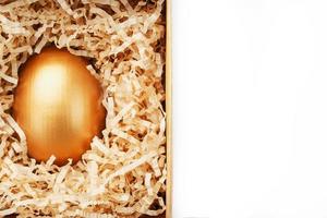 Golden egg in a box on a white background concept of exclusivity, best choice, prize, special surprise, expensive gift. The concept of minimalism. photo