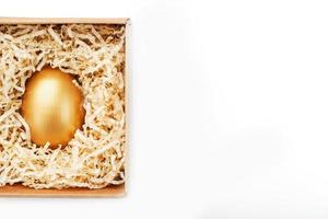 Golden egg in a box on a white background concept of exclusivity, best choice, prize, special surprise, expensive gift. The concept of minimalism. photo