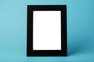 Black photo frame with empty space on a blue background.