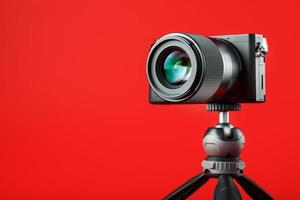 Photo video camera with a tripod, on a red background.