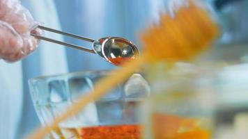 The cook pours honey into the transparent bowl. Use a wooden spoon for honey video