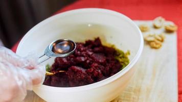 a garota prova pkhali. comida georgiana tradicional pkhali. a beterraba é usada para a cor roxa. a noz é usada para a decoração video